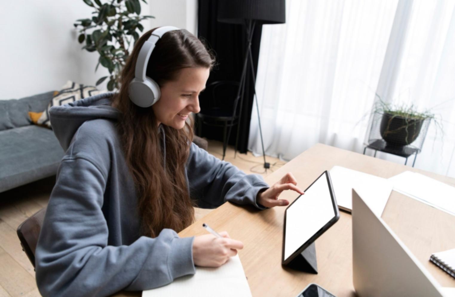Person arbeitet konzentriert an Finanzunterlagen und Laptop